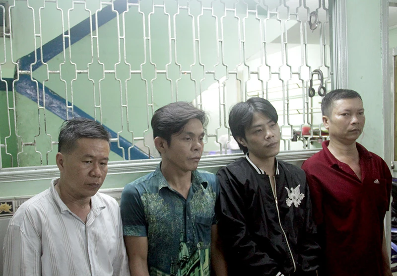 Thanh (áo trắng, bên trái) bị bắt giữ cùng đồng bọn. 